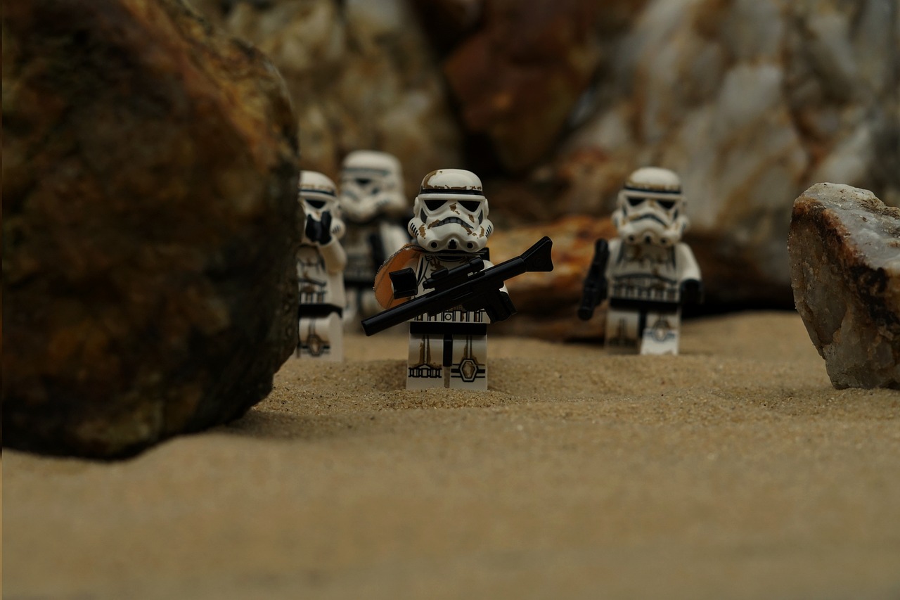 a group of star wars figurines standing next to each other, inspired by George Lucas, unsplash, realism, storming the beaches of normandy, with a white muzzle, standing on rocky ground, lego style