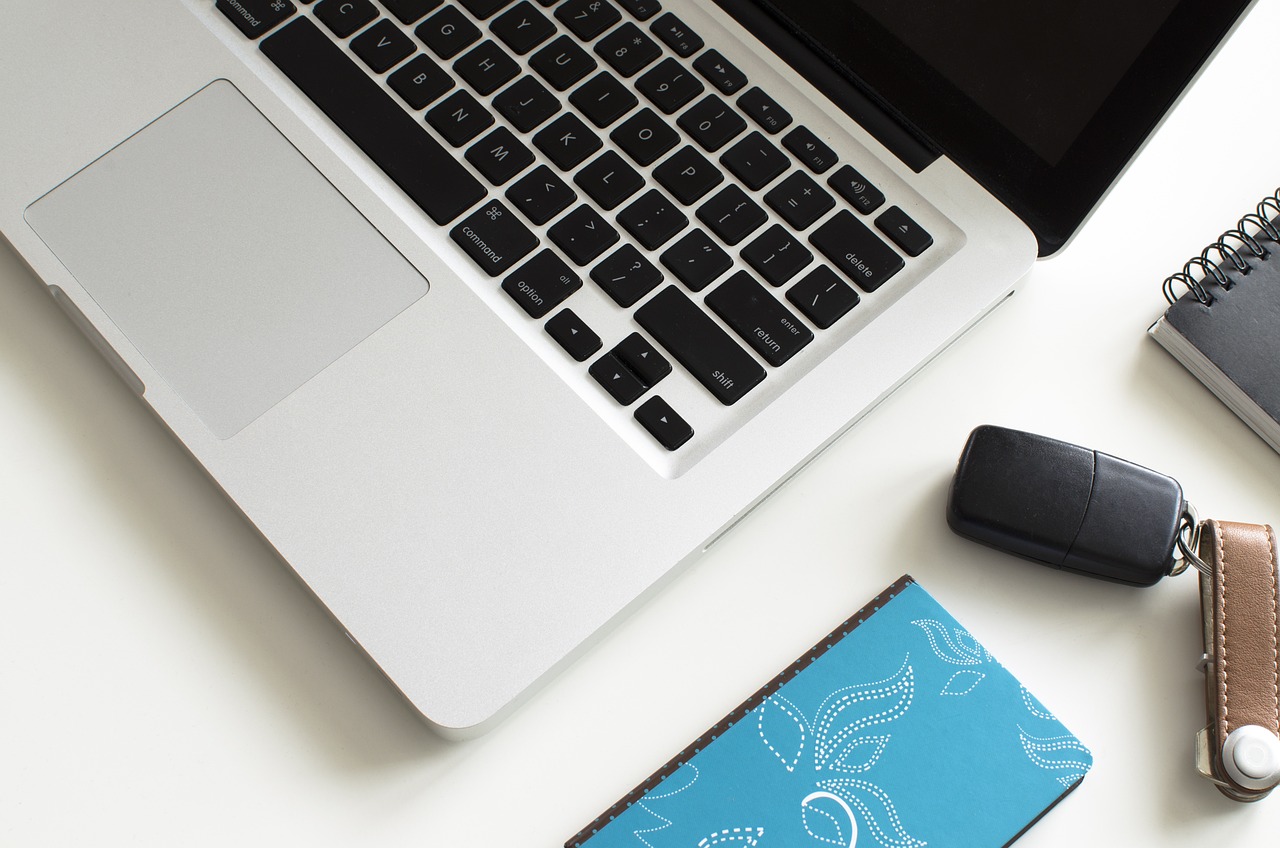 a laptop computer sitting on top of a white desk, by Carey Morris, pexels, silver and blue color schemes, bottom angle, cyan, computer mouse