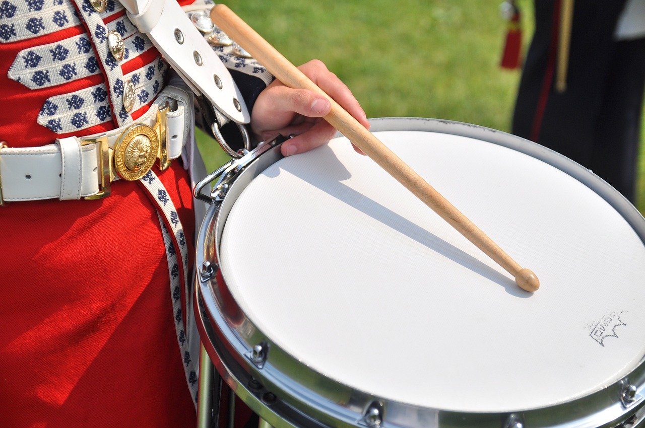 a close up of a person holding a drum, by Edward Corbett, shutterstock, military parade, with trident and crown, panning shot, ground breaking