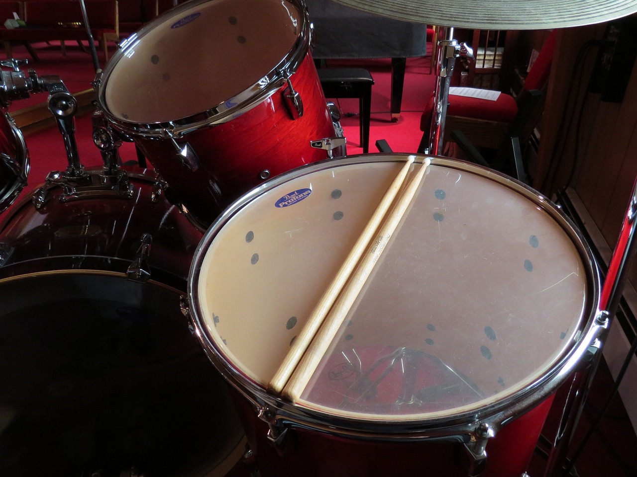 a close up of a drum with a pair of drumsticks, by Wayne England, purism, symmetric!, drum pads, focal depth, slightly red