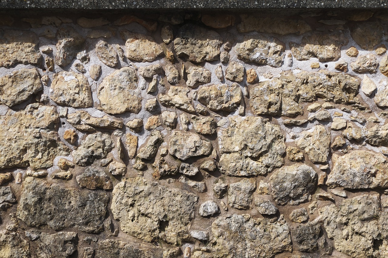 a red fire hydrant sitting in front of a stone wall, shutterstock, romanesque, texture for 3d, rock roof, gravel, 14th century