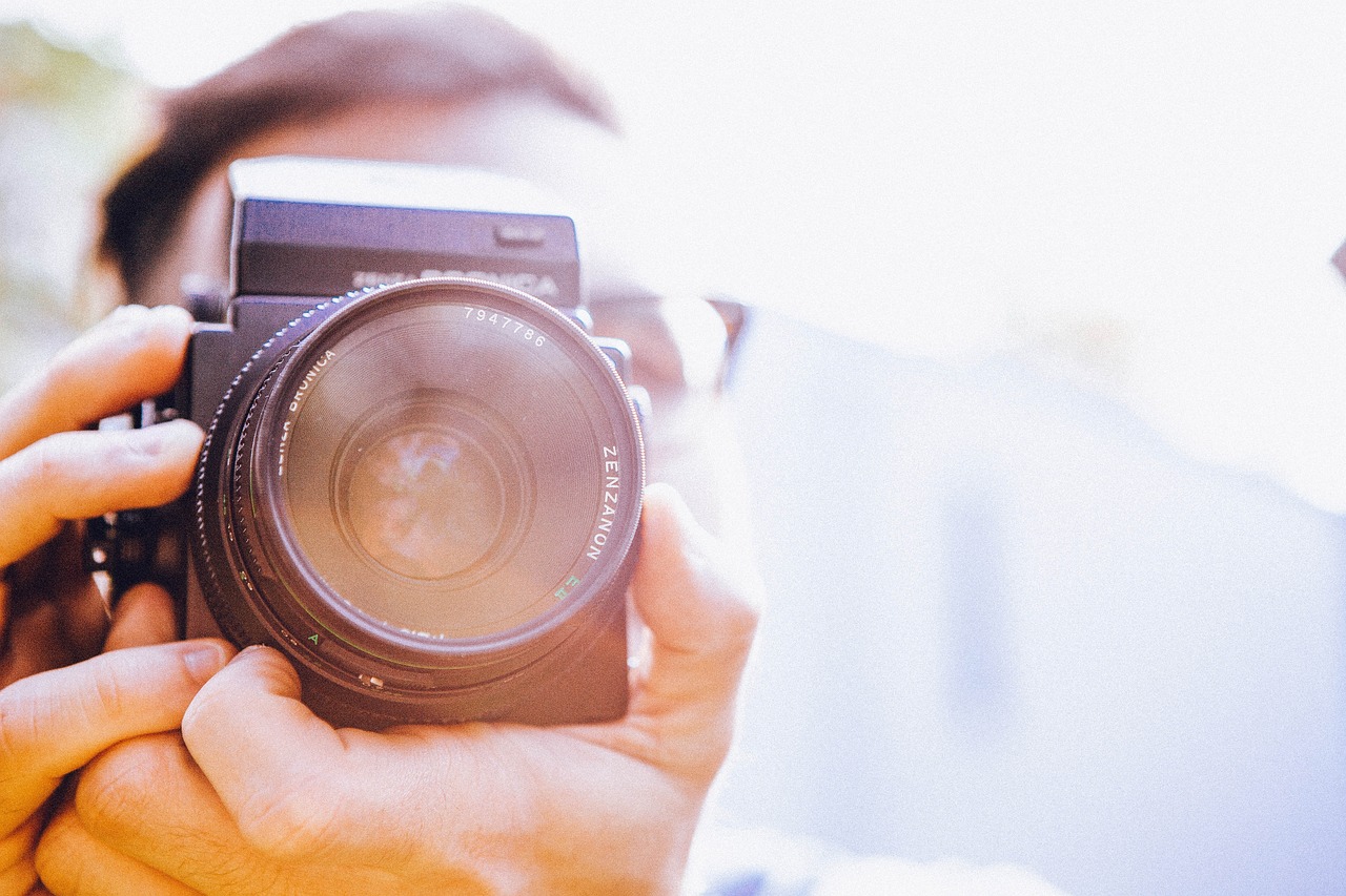 a person taking a picture with a camera, a picture, lens glare, holding it out to the camera, avatar image