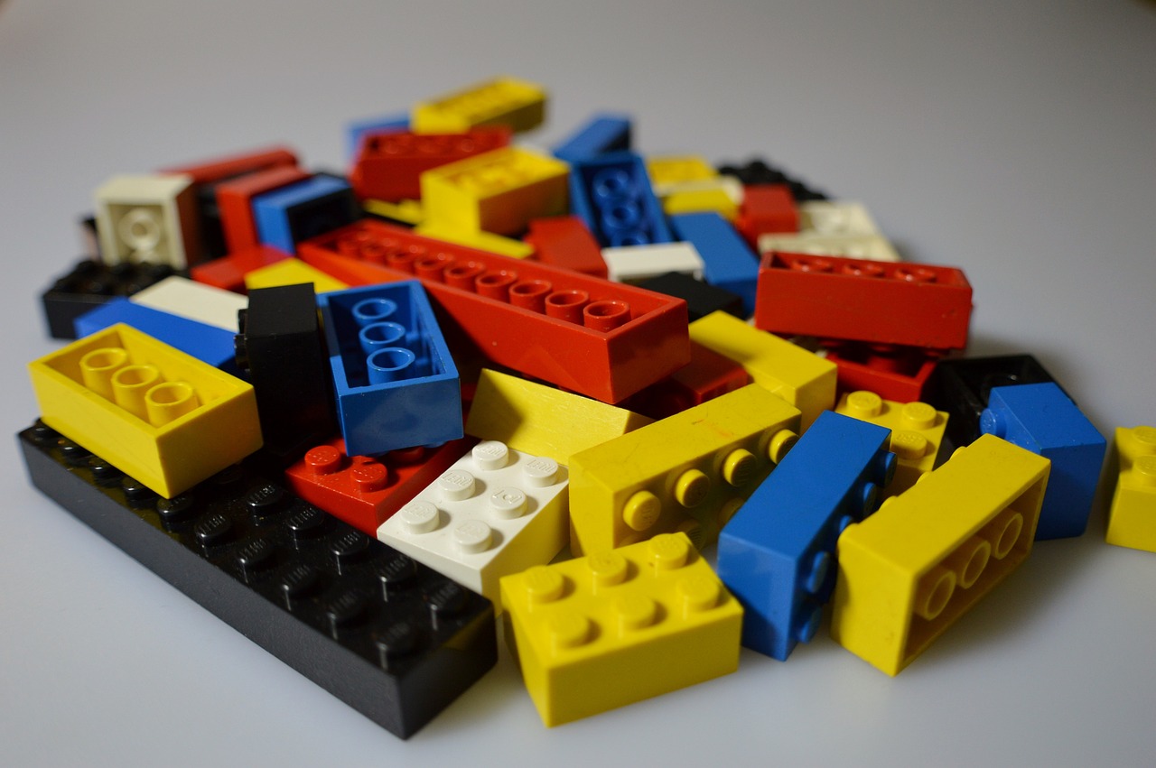a pile of legos sitting on top of a table, a picture, pexels, modular constructivism, yellows and reddish black, blue, seen from below, primary colors are white