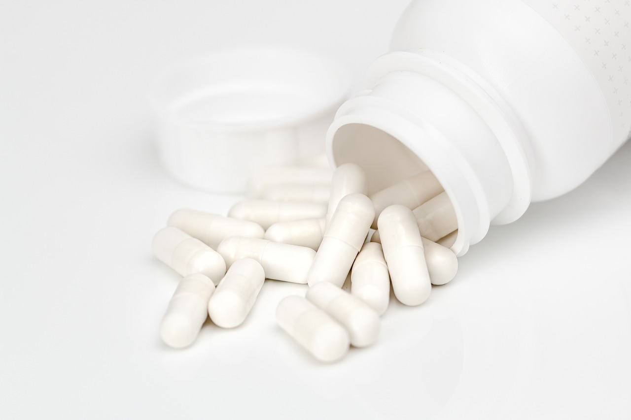 a close up of a bottle of pills on a table, shutterstock, antipodeans, white finish, highly detailed product photo