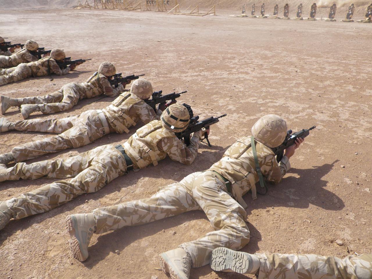 a group of soldiers laying on the ground, a picture, by Richard Carline, shutterstock, firing laser rifle, oman, pokemon military drill, stock photo