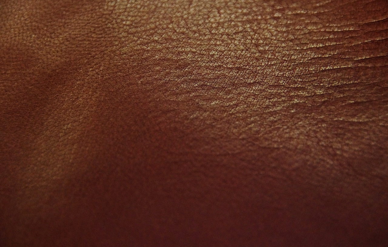 a close up of a brown leather surface, a picture, unsplash, reddish lighting, close up of lain iwakura, soft vinyl, dark skin tone