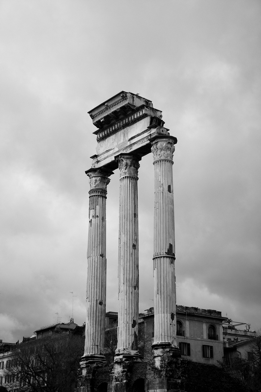 a black and white photo of two columns, by Davide Sasselli, neoclassicism, ( ( ruins of ancient rome ) ), on a cloudy day, aged photo