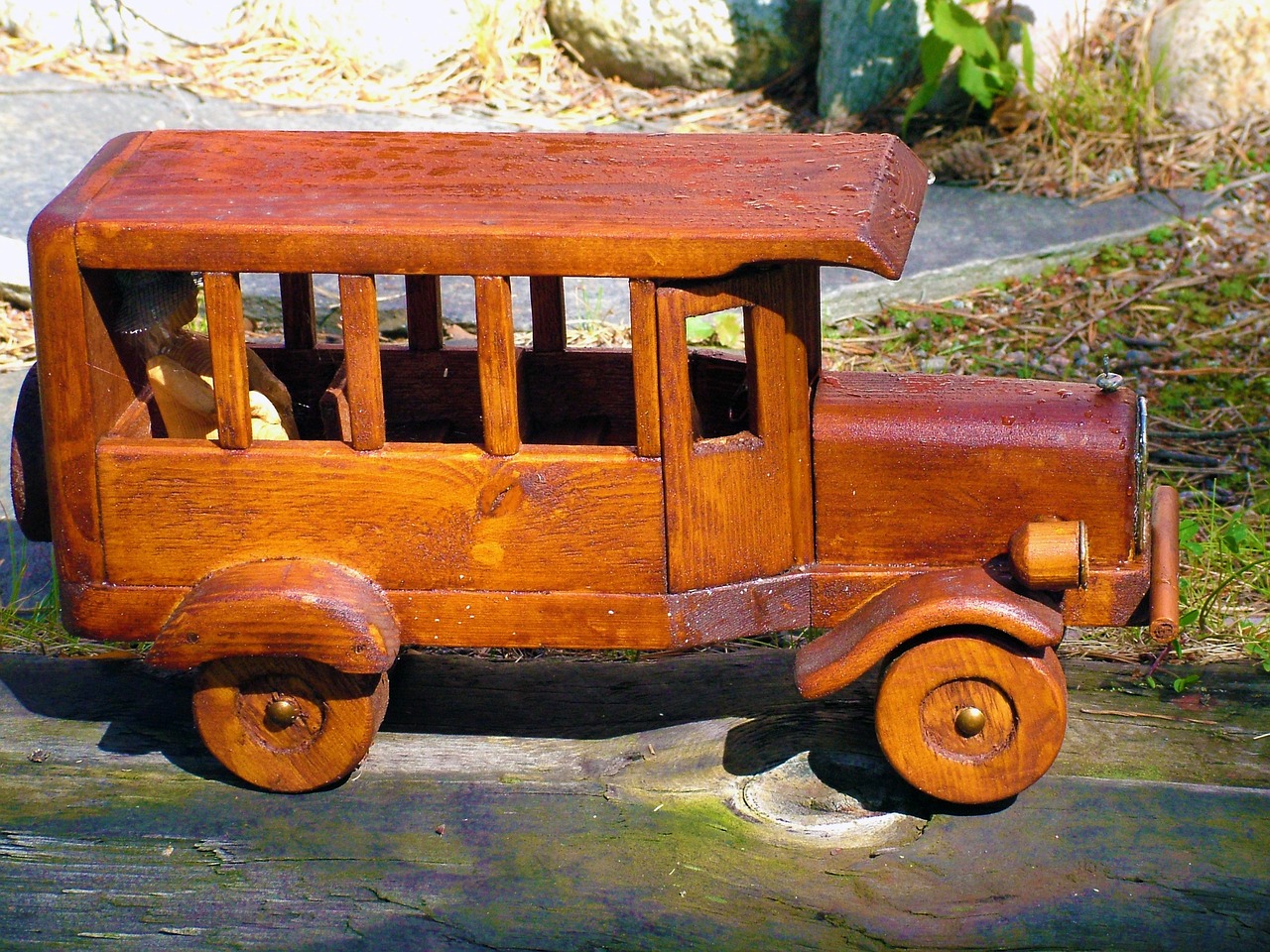 a wooden toy bus sitting on top of a rock, by Albert Swinden, flickr, folk art, old car, very detailed ”, vintage - w 1 0 2 4, [ closeup ]!!