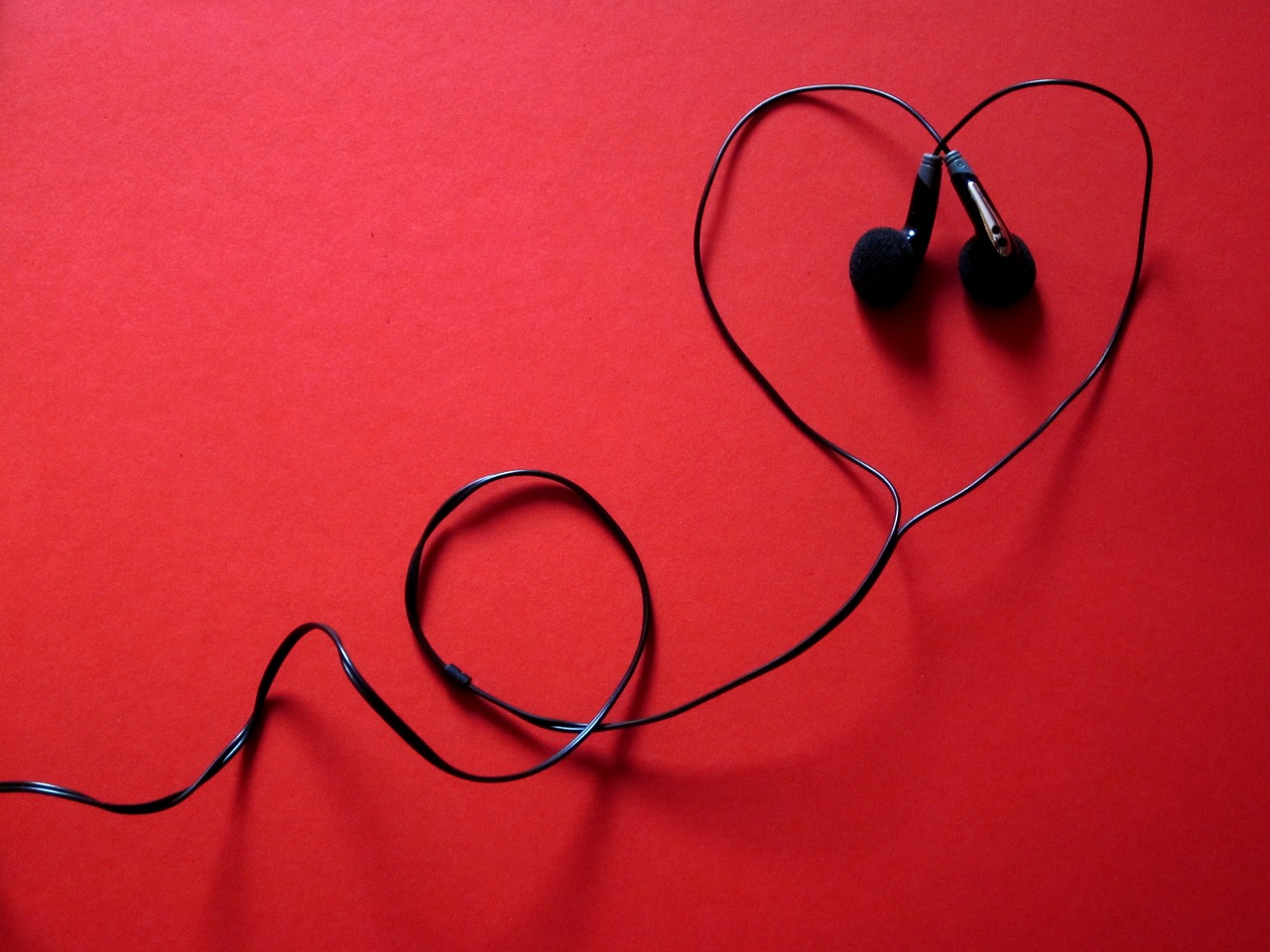 a pair of headphones in the shape of a heart, istockphoto, red wallpaper background, small gadget, stringy