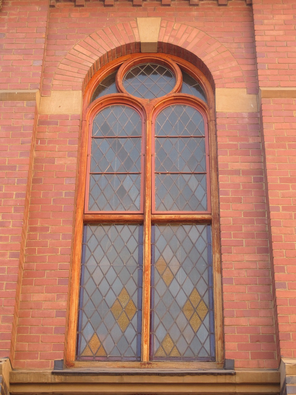 a red brick building with a stained glass window, a photo, inspired by Sydney Prior Hall, natural light window, superior detail, restoration, part of the screen
