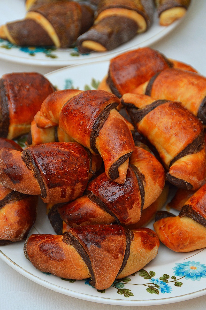 a plate that has some croissants on it, inspired by Slava Raškaj, hurufiyya, kazakh, chocolate, crispy buns, traditional medium