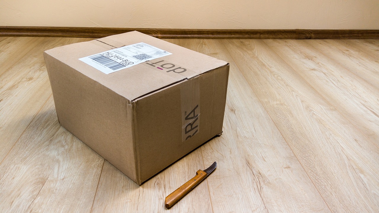 a cardboard box sitting on top of a hard wood floor, including a long tail, more details, order, postage