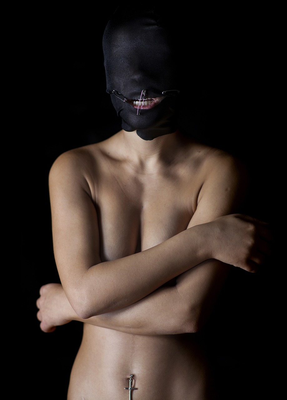 a close up of a person with a mask on, a portrait, by Maciej Kuciara, antipodeans, covered breasts, large black smile, naughty expression, closed-mouth smile