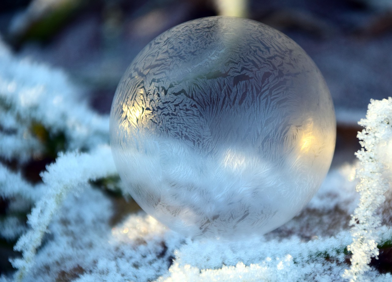 a glass ball sitting on top of snow covered ground, inspired by Arthur Burdett Frost, the stone is rolling up, frost gem, dry ice, soft - warm