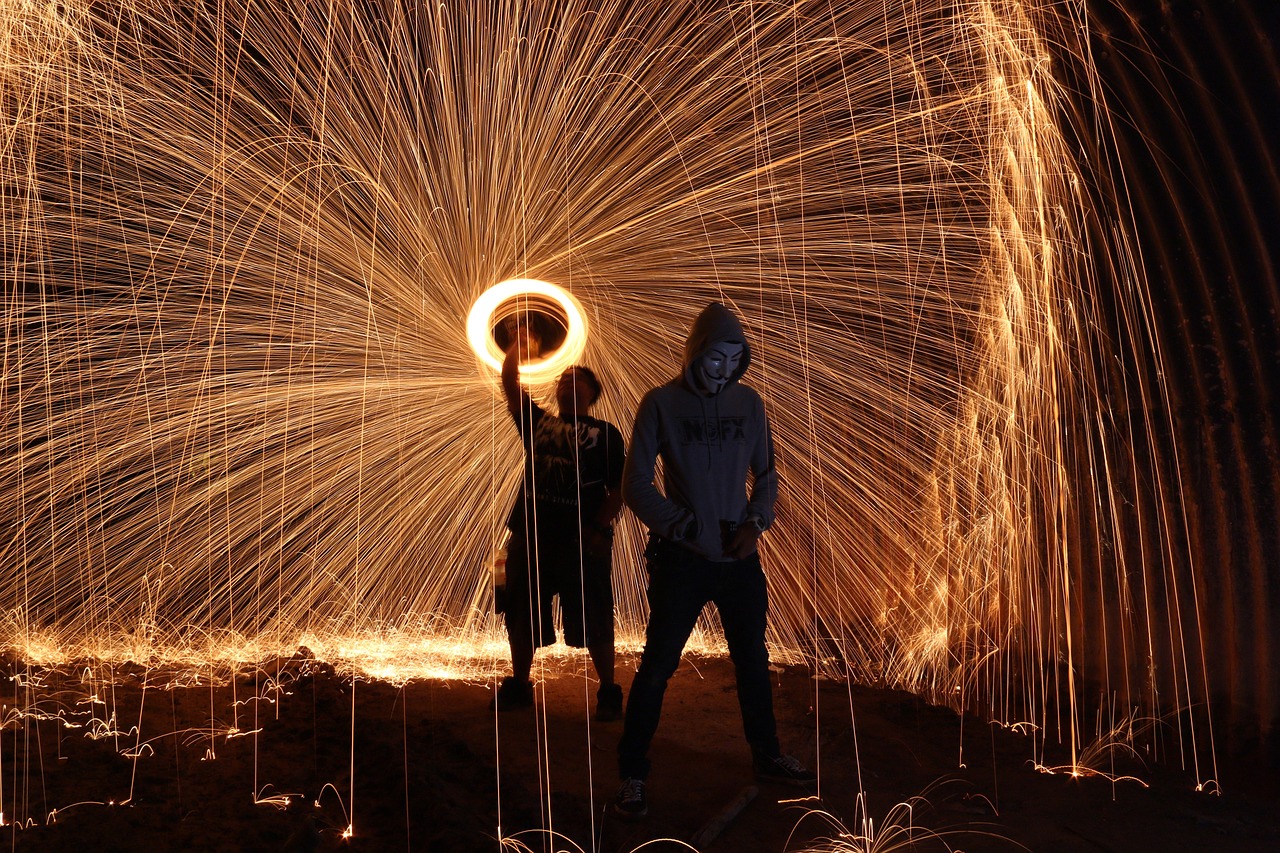 a couple of people standing in front of a fire, flickr, interactive art, a glowing halo, sparks, absolutely outstanding image, wall torches