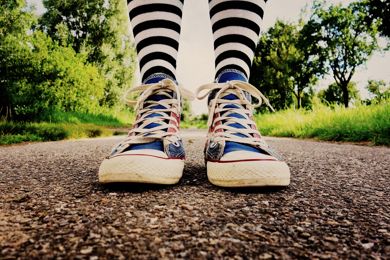 a close up of a person's shoes on a road, trending on pixabay, realism, striped pantyhose, converse, carnival, looking happy