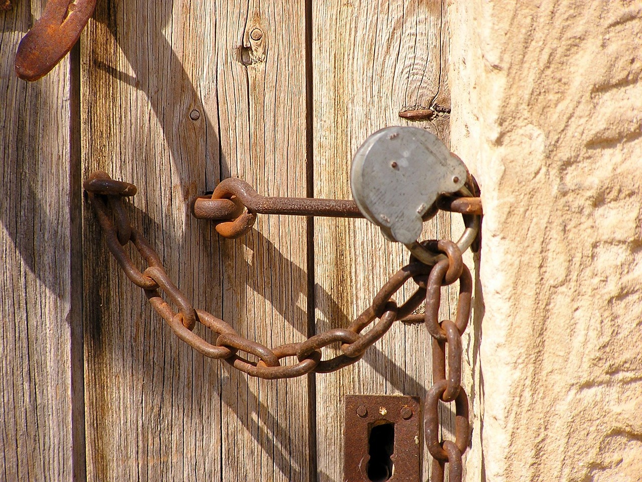 a close up of a lock on a wooden door, by Istvan Horkay, renaissance, ((chains)), ibiza, version 3, haggard