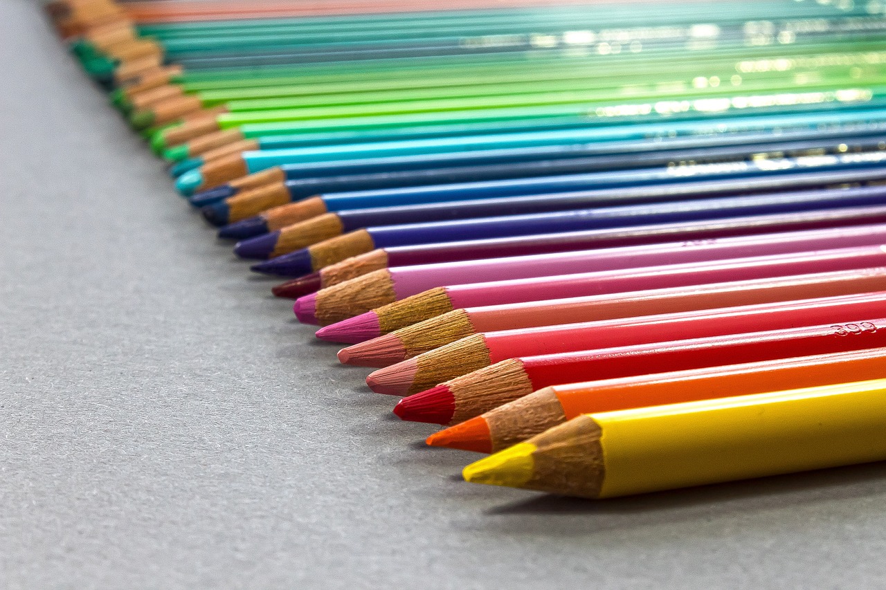 a row of colored pencils sitting on top of a table, a color pencil sketch, crayon art, very sharp photo, on a gray background, modern high sharpness photo