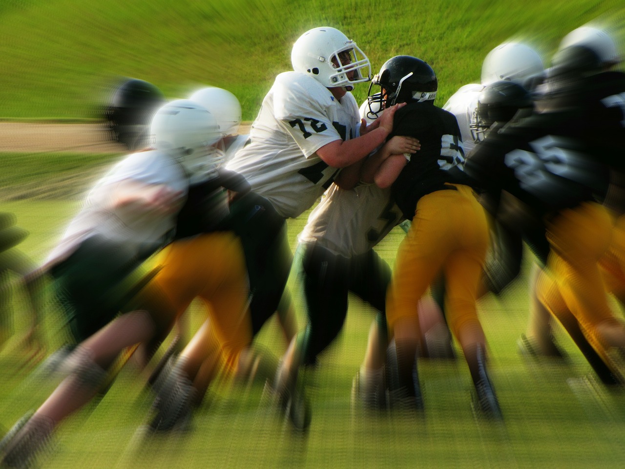 a group of young men playing a game of football, a tilt shift photo, by Ken Elias, shutterstock, full helmet, iowa, posterized, high exposure photo