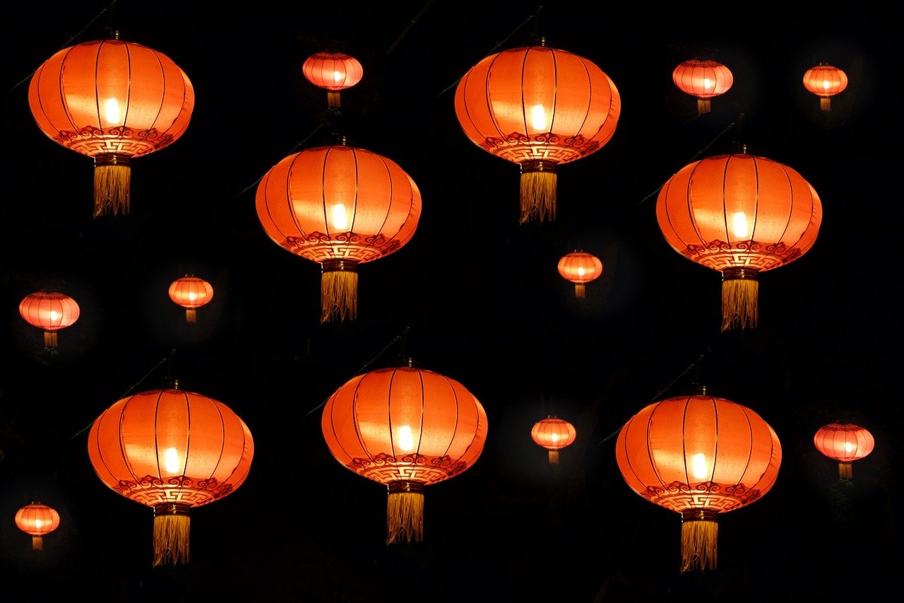 a bunch of red lanterns hanging from a ceiling, a picture, inspired by Shang Xi, pexels, happening, orange lamp, in front of a black background, istockphoto, wide screenshot