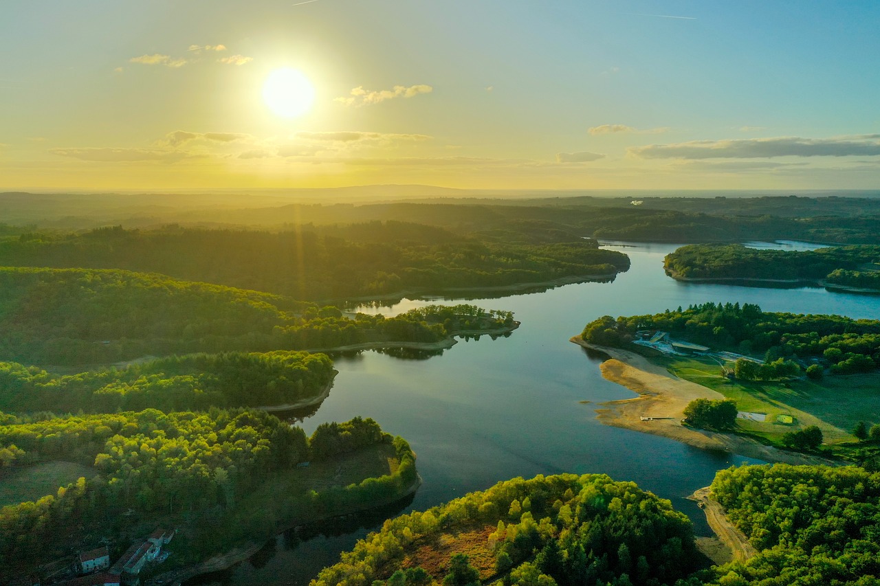 a large body of water surrounded by trees, a picture, by Karl Hagedorn, shutterstock, sun lighting from above, brockholes, air shot, great river