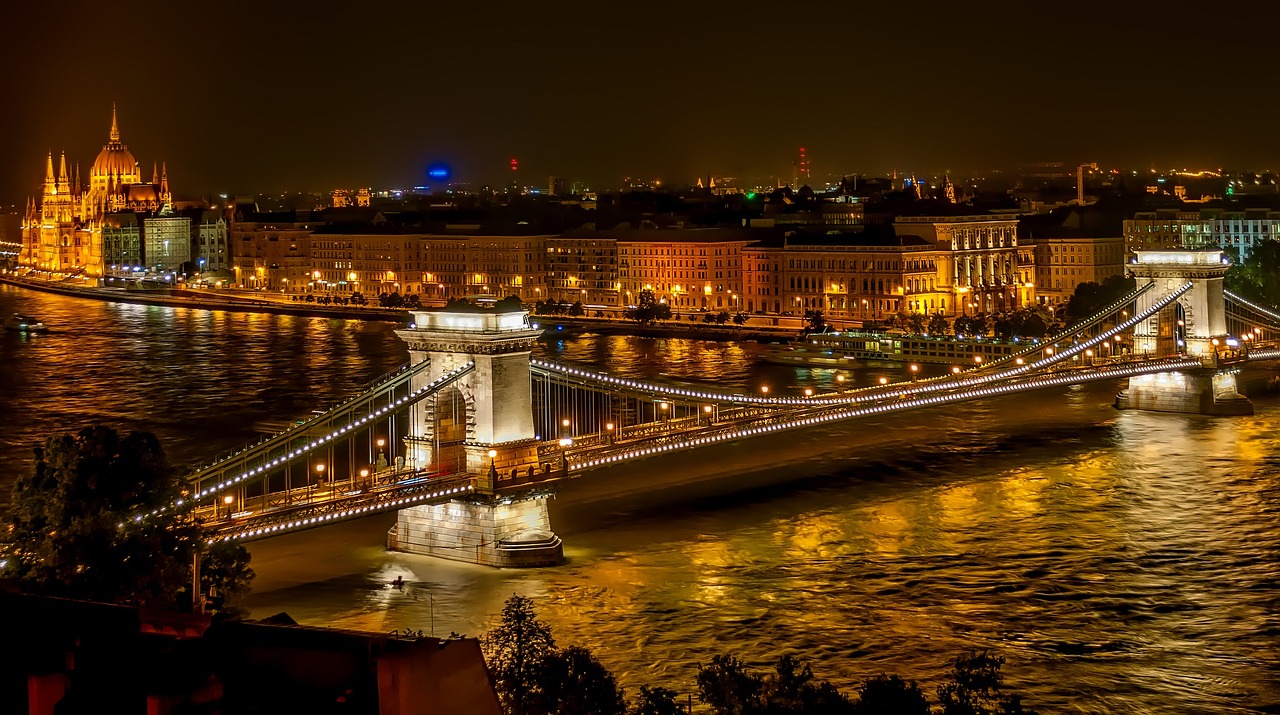 a view of a bridge over a river at night, a picture, by Adam Szentpétery, shutterstock, budapest, liquid gold, a blond, wallpaper - 1 0 2 4