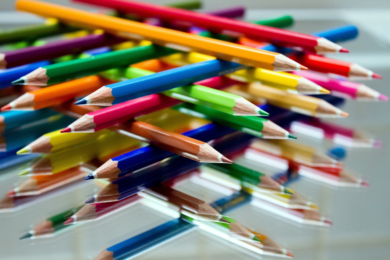 a close up of a bunch of colored pencils, by Richard Carline, crayon art, tilt shift glass background, symmetrically, reflections and refractions, an artistic pose