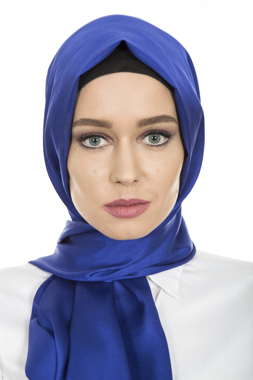 a woman wearing a blue scarf and a white shirt, a portrait, inspired by Maryam Hashemi, shutterstock, wearing professional makeup, - h 7 0 4, blue head, stylized portrait h 704
