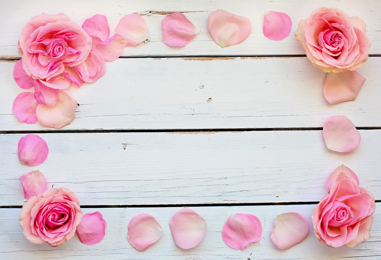 pink rose petals and petals arranged in the shape of a heart, romanticism, wooden background, crown of peach roses, white borders, deck