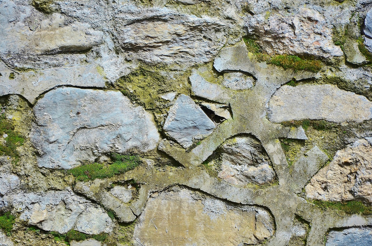 a stone wall with moss growing on it, a mosaic, inspired by Andy Goldsworthy, pexels, concrete art, some grungy markings, very very well detailed image, polygonal fragments, plaster