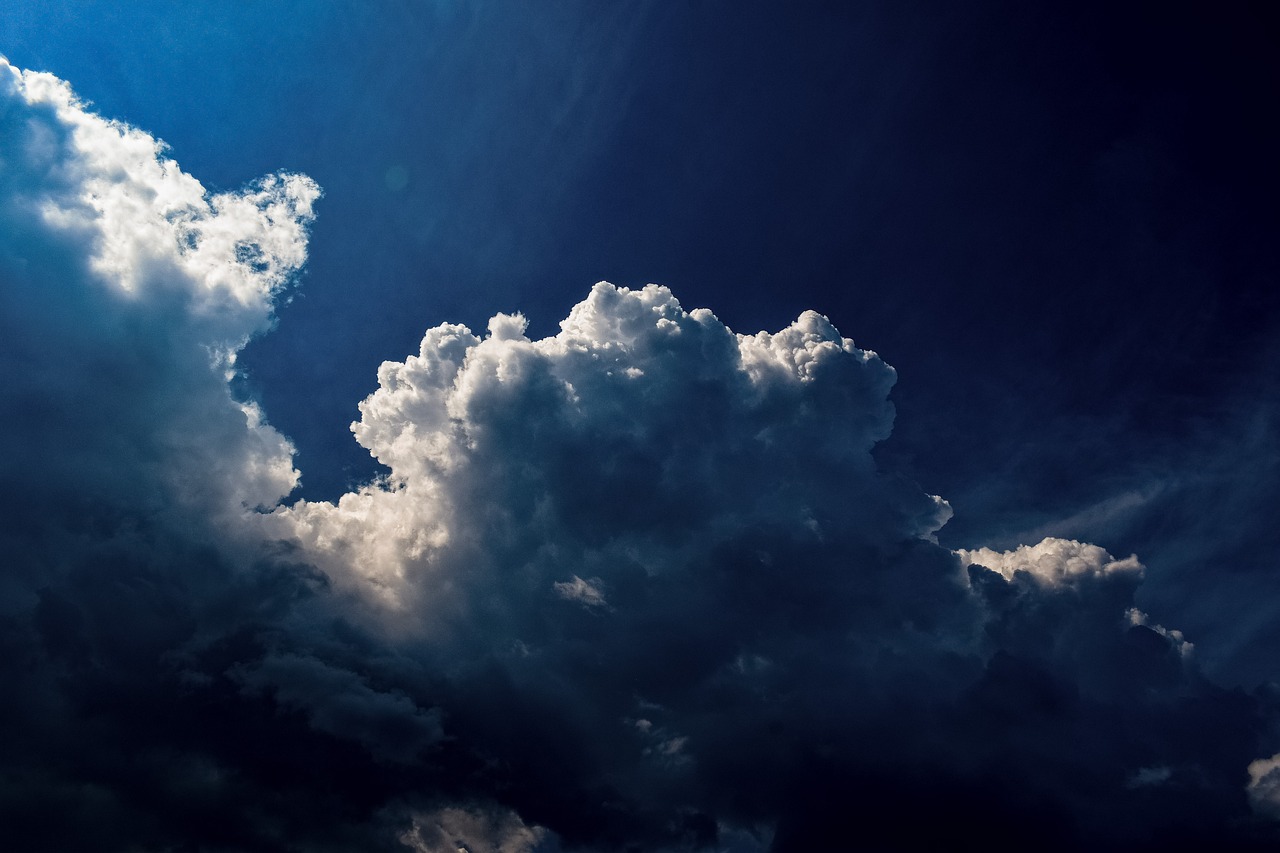 a jetliner flying through a cloudy blue sky, a picture, by Matthias Weischer, romanticism, sunlight through cumulus, dark night stormcloud, cloud in the shape of a dragon, beautiful cloudy deep blue sky