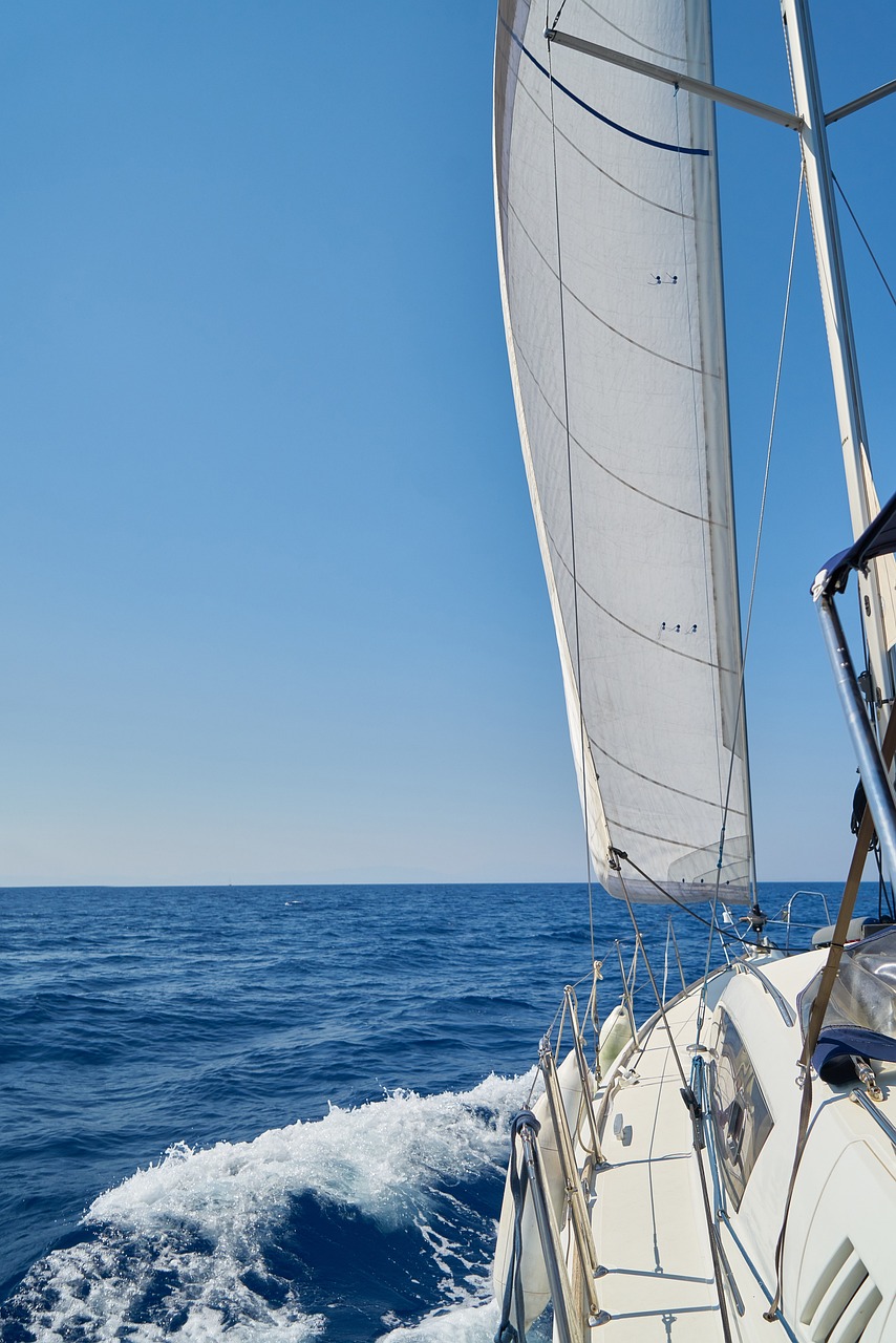 a man on a sailboat in the middle of the ocean, a picture, by John Murdoch, shutterstock, low angle wide shot, big long cloth on the wind, banner, on a bright day