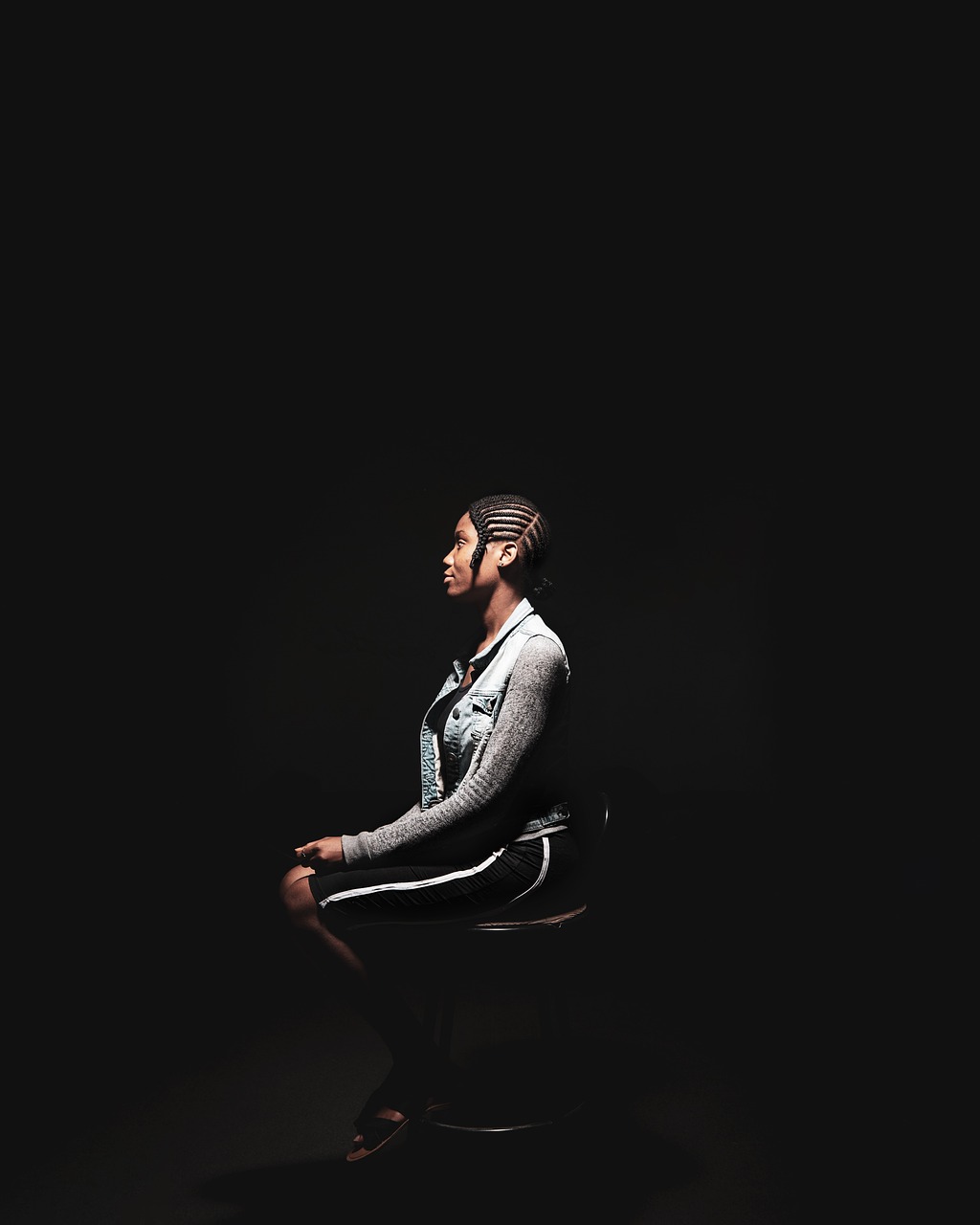 a man sitting in a chair in the dark, digital art, handsome hip hop young black man, on a mannequin. studio lighting, meditating in lotus position, singer maluma