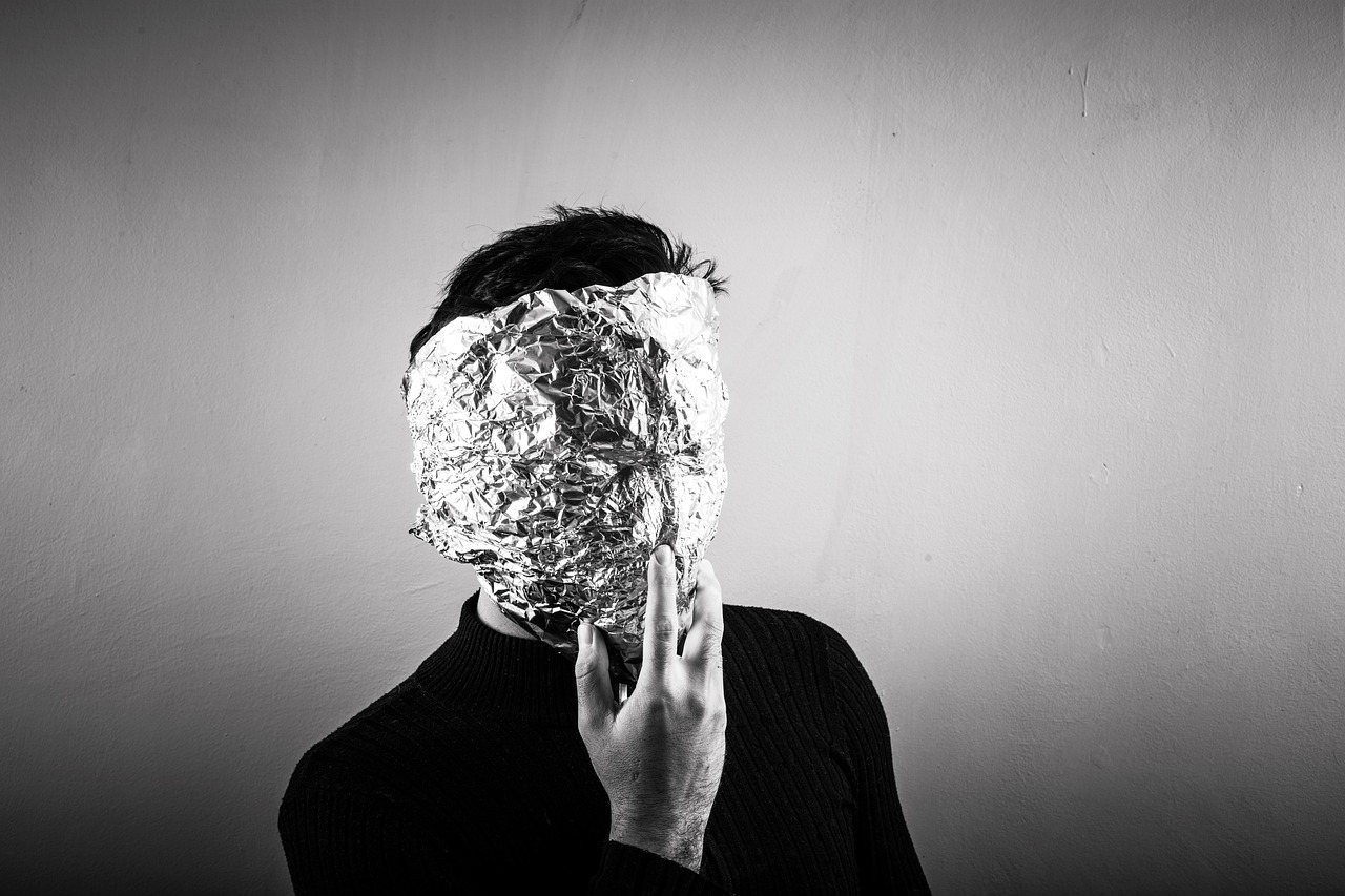 a black and white photo of a woman covering her face with foil, pexels, minimalism, the man with robot head, self portrait, american man, food head