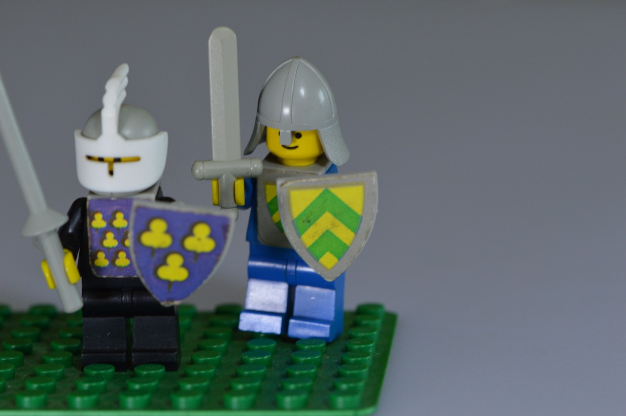 a couple of lego knights standing next to each other, a picture, inspired by Simon de Vlieger, flickr, shield, some yellow green and blue, tiny, mid shot photo