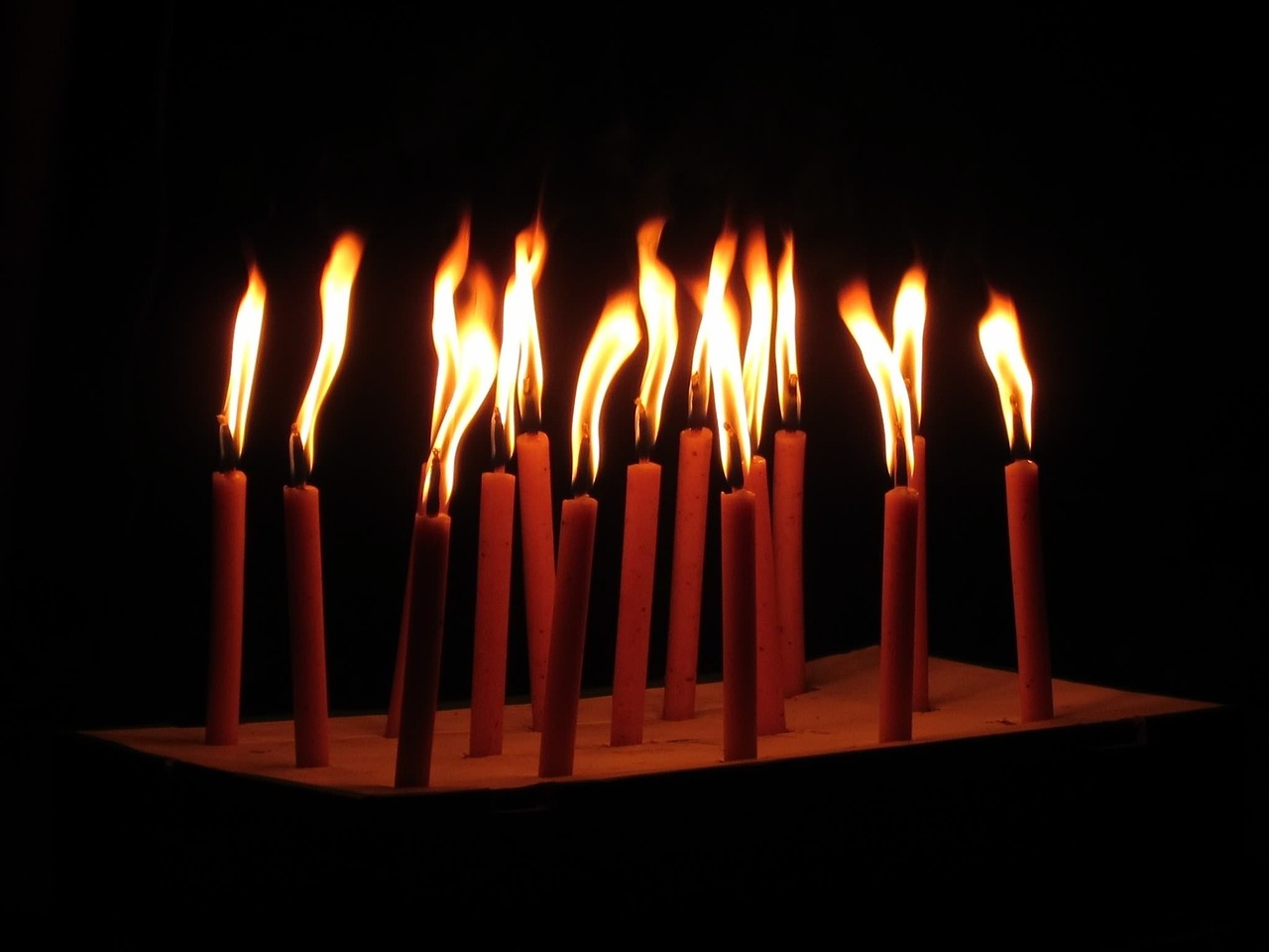 a group of lit candles sitting on top of a table, a picture, by Tom Carapic, birthday, greek, background ( dark _ smokiness ), file photo