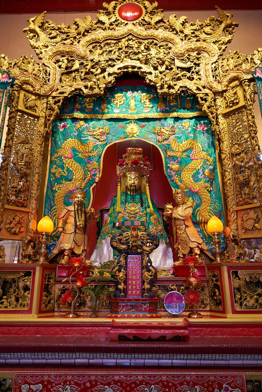 a gold statue sitting on top of a red table, an ultrafine detailed painting, cloisonnism, on the altar, dragon pope, gold and teal color scheme, intricate environment - n 9