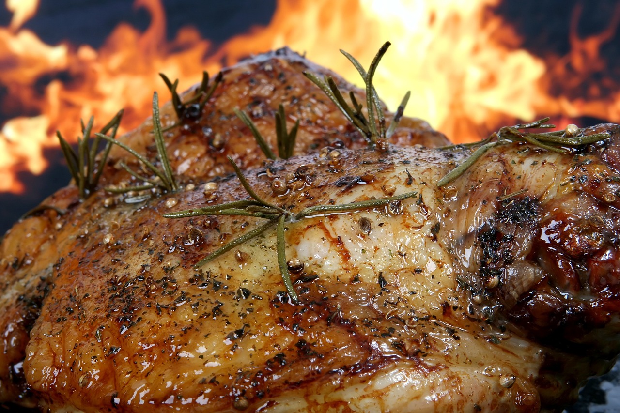 a close up of meat on a grill with flames in the background, a digital rendering, by Rodney Joseph Burn, pixabay, realism, chicken feathers, recipe, lamb and goat fused as one, turkey