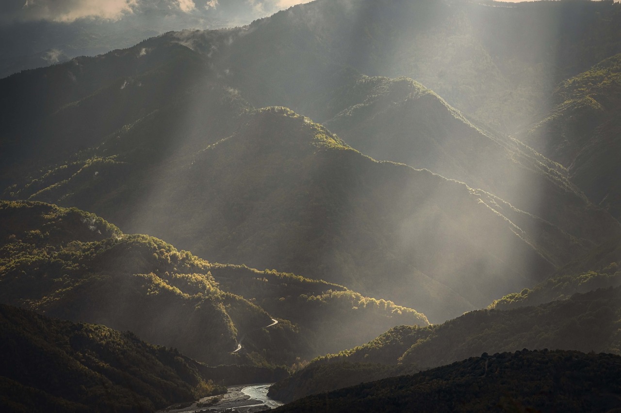 the sun shines through the clouds over the mountains, by Giuseppe Grisoni, unsplash contest winner, romanticism, georgic, river gorgeous lighting, flowing hills, dramatic light 8 0 mm camera