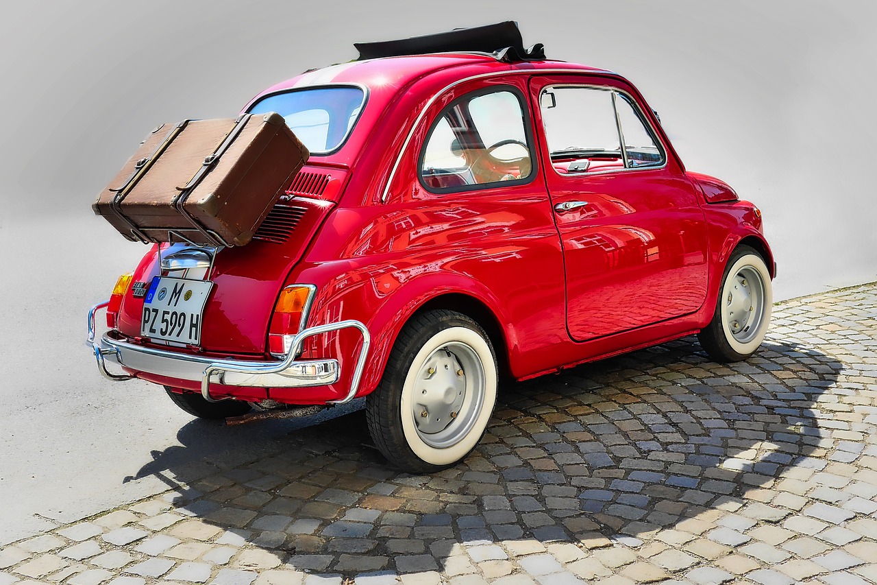 a small red car with luggage on top of it, by Carlo Maderna, trending on pixabay, renaissance, 60s style, 6 4 0, great light, forward facing