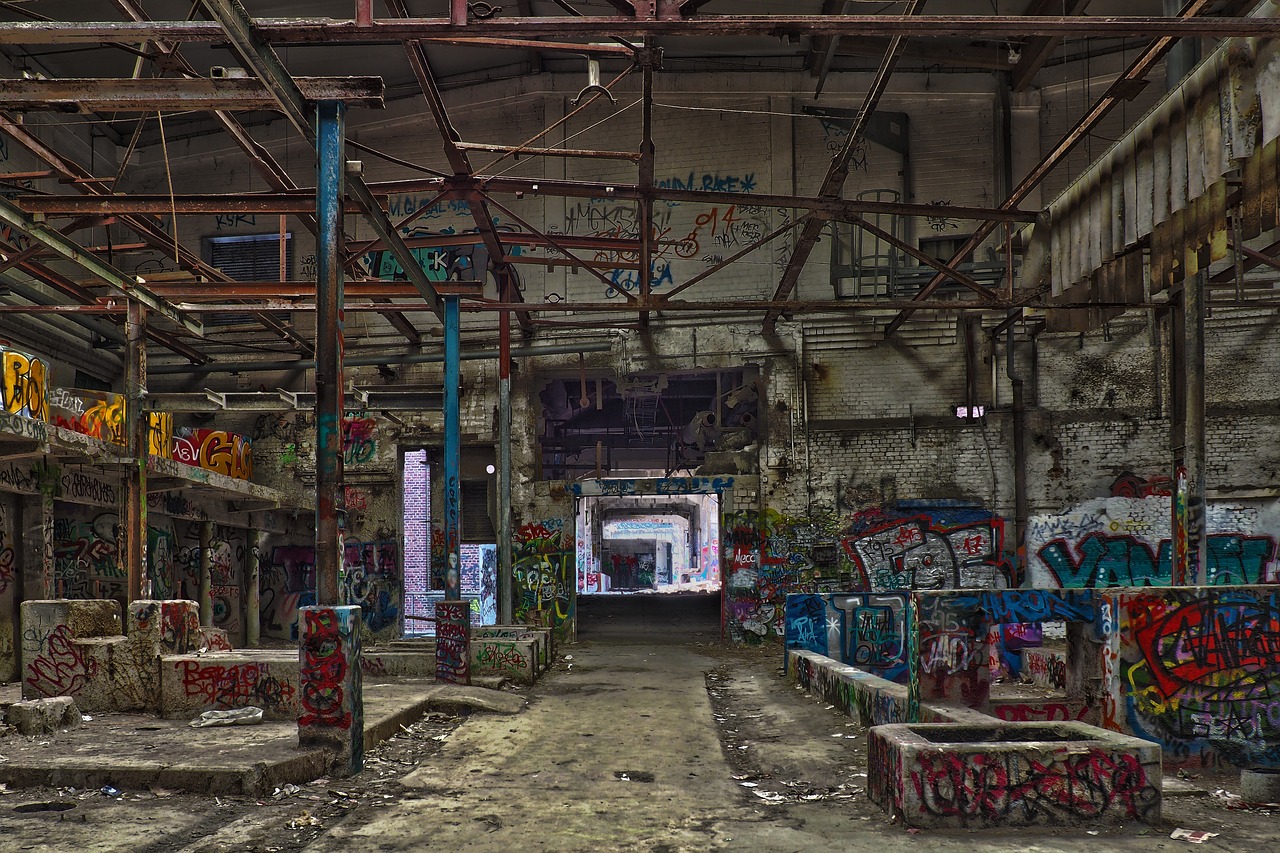 a room filled with lots of graffiti covered walls, by Richard Carline, flickr, abandoned night hangar, colour corrected, nature taking over, late morning