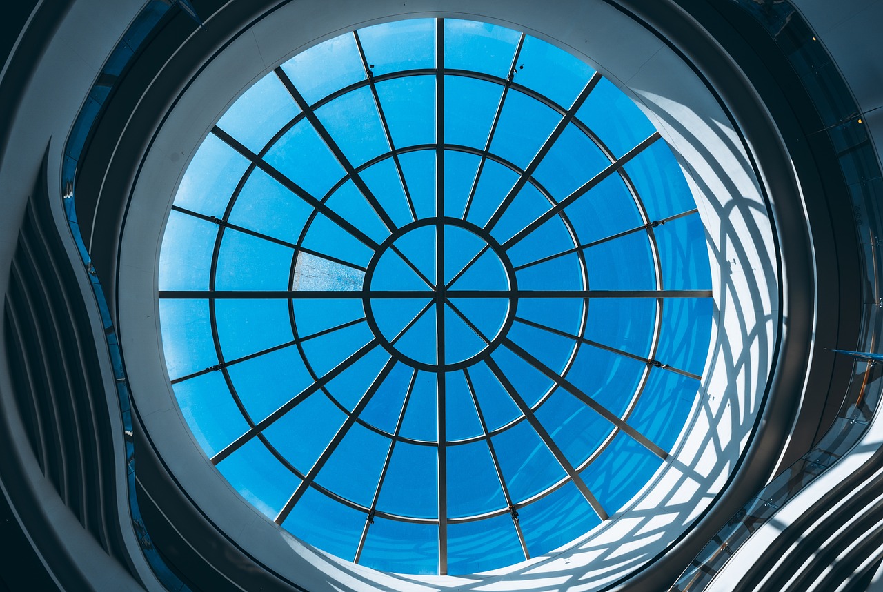 a circular window in a building with a blue sky in the background, skylight open ceiling, highly detail wide angle photo, 1128x191 resolution, a huge glass tank