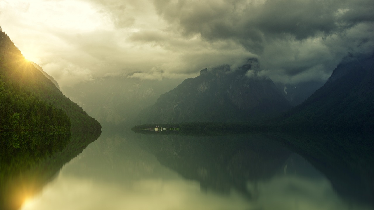 a body of water surrounded by mountains under a cloudy sky, a picture, by Karl Buesgen, minimalism, beautiful reflexions, wide film still, storm in the evening, boka