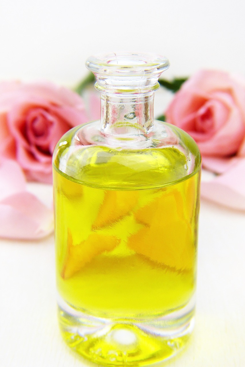 a close up of a bottle of oil with flowers in the background, a picture, it has lemon skin texture, rose petals, featured, ready - made