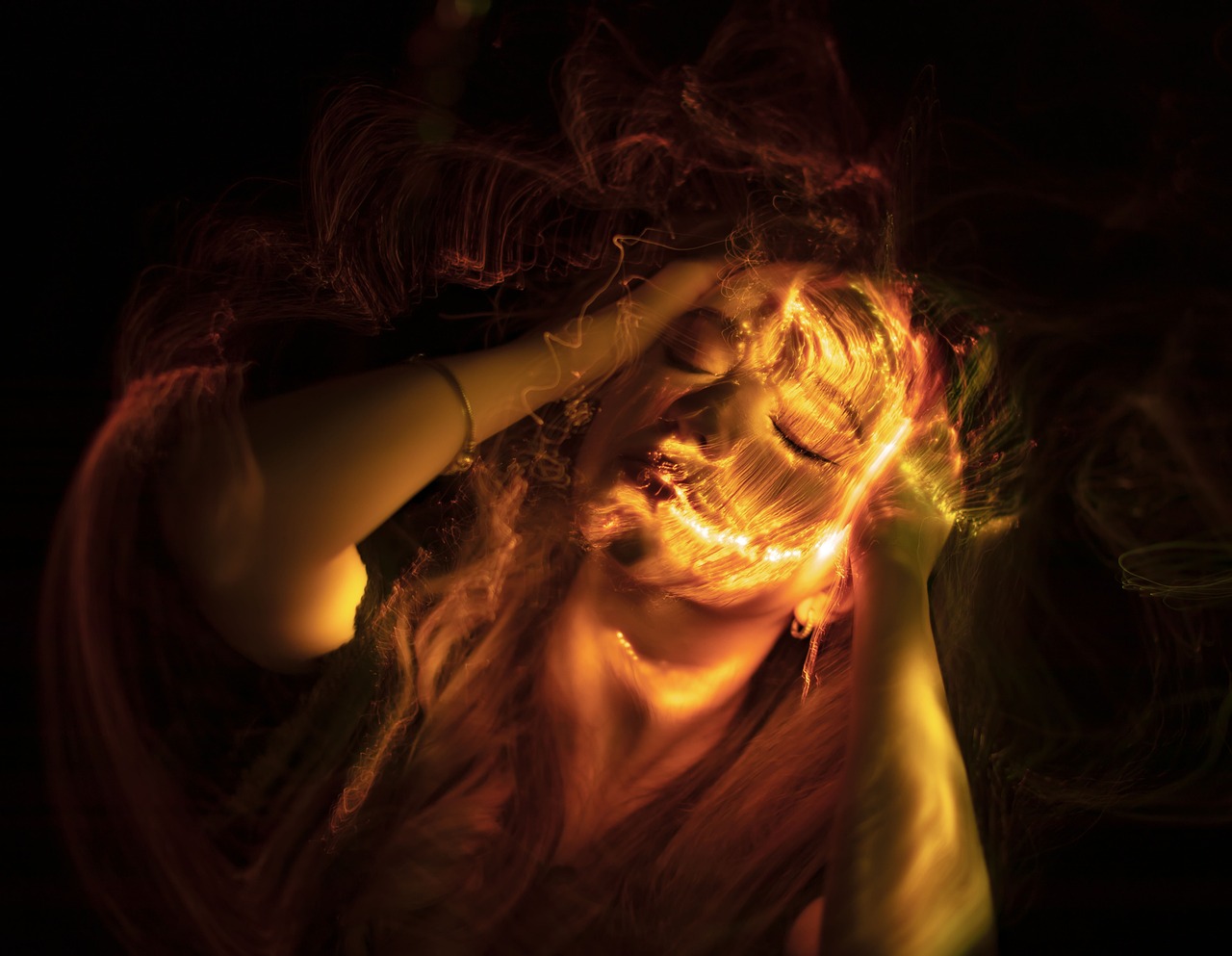 a woman with her hair blowing in the wind, a portrait, by Adam Marczyński, pexels, digital art, dramatic fire glow lighting, glowing yellow face, astral projection, headbanging
