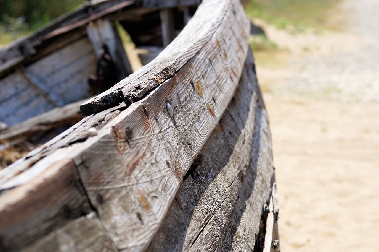 a wooden boat sitting on top of a sandy beach, a picture, renaissance, shack close up, detailed close up shot, battle-worn, rails