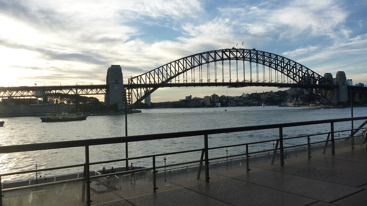 a body of water with a bridge in the background, a picture, inspired by Sydney Carline, hurufiyya, photo taken in 2018, viewed from the harbor, metallic bridge, ready to eat