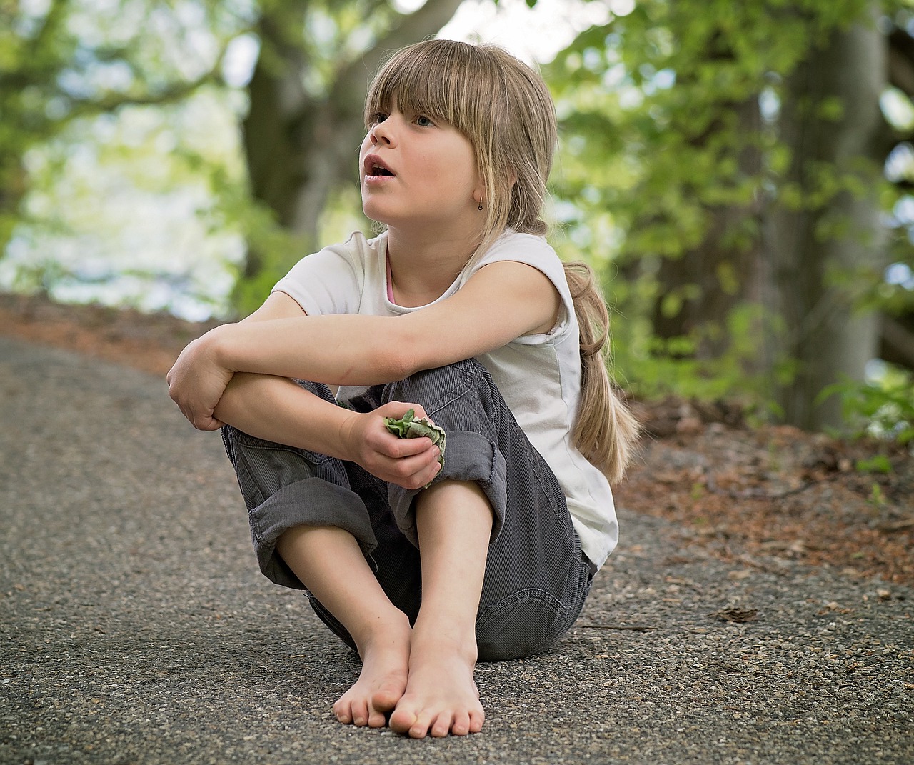 a little girl sitting on the side of a road, a picture, by Dietmar Damerau, pixabay, realism, warts, forest fairy, feeling of disgust, lizard pose