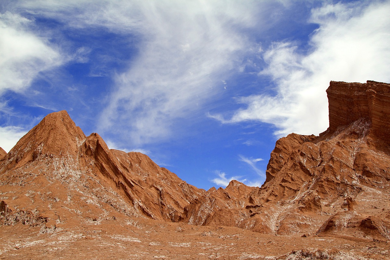 a person riding a horse through a desert, figuration libre, landscape with red mountains, mars vacation photo, blue sky and white clouds, deep crevices of stone