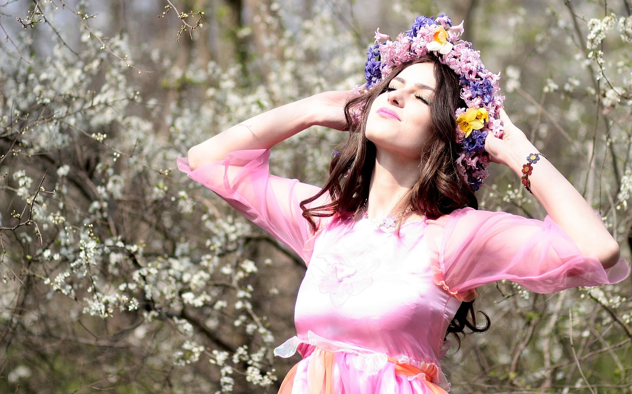 a woman in a pink dress with flowers in her hair, by Marie Bashkirtseff, pexels, goddess of spring, 7 0 s style, happy girl, ukrainian girl